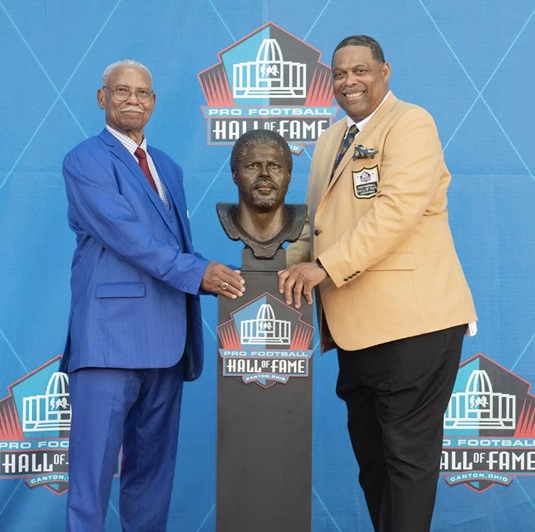 Robert Brazile beside his Pro Football Hall of Fame bust