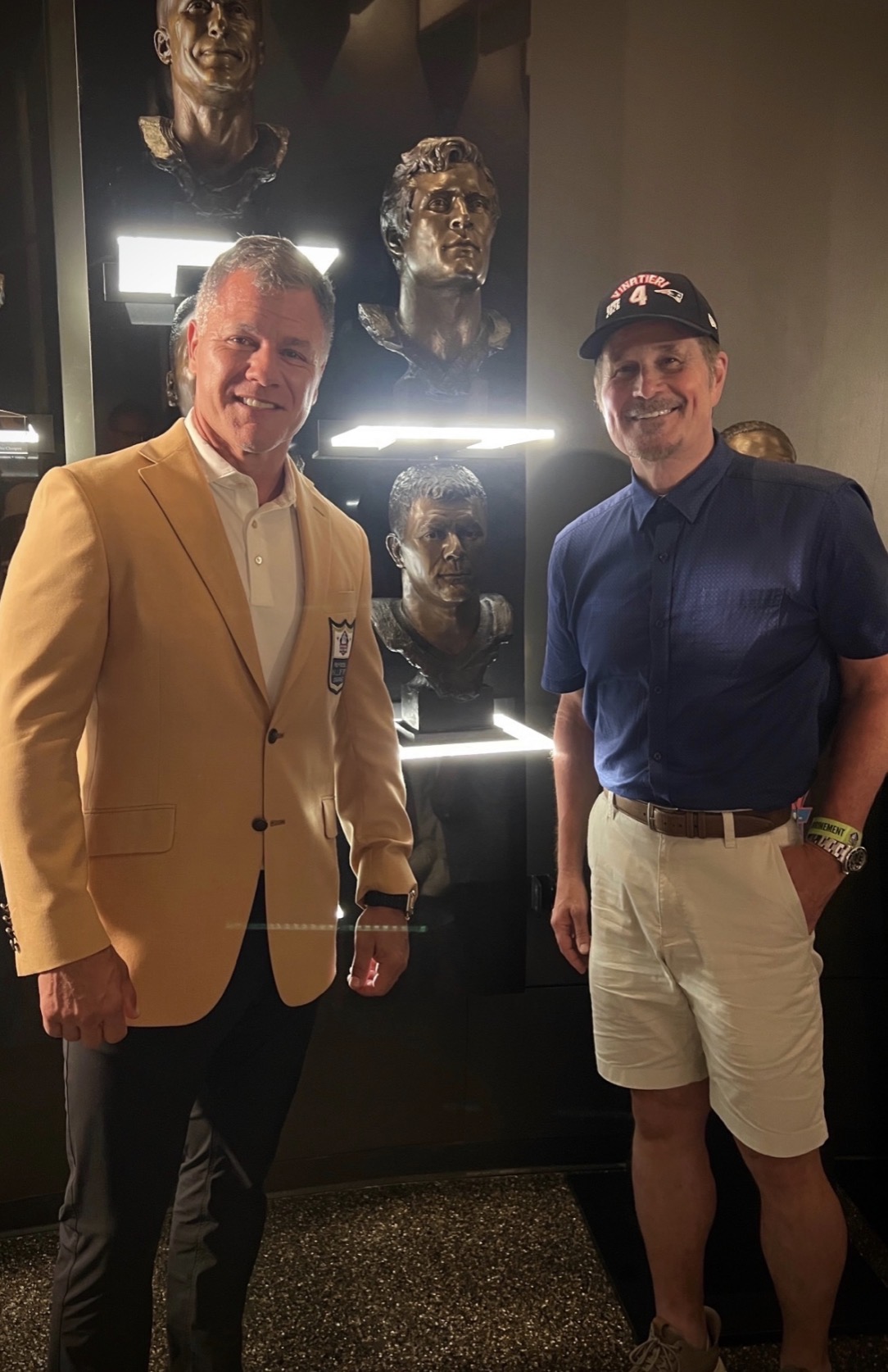 Adam Vinatieri standing with sculptor Scott Myers beside his portrait bust display